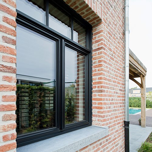 fenêtre en aluminium noir avec profilés en aluminium sur nouvelle construction avec brique orange clair et joints blancs