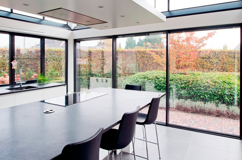 ruime moderne keuken met natuurlijke lichtinval dankzij aluminium lichtstraat en grote zwarte aluminium ramen met grote glaspartijen