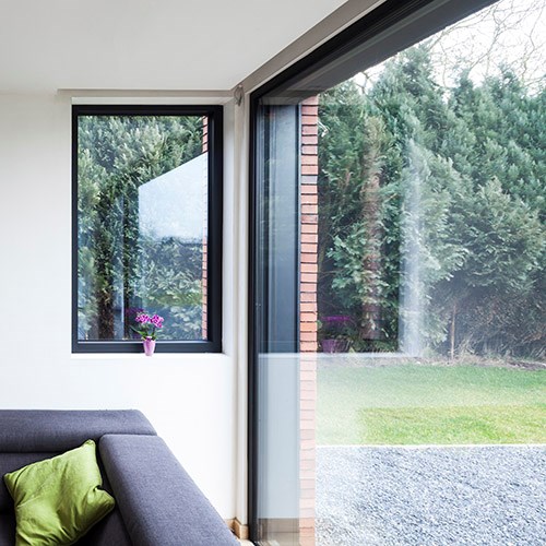 Grande fenêtre avec profilés en aluminium noir avec vue sur le jardin