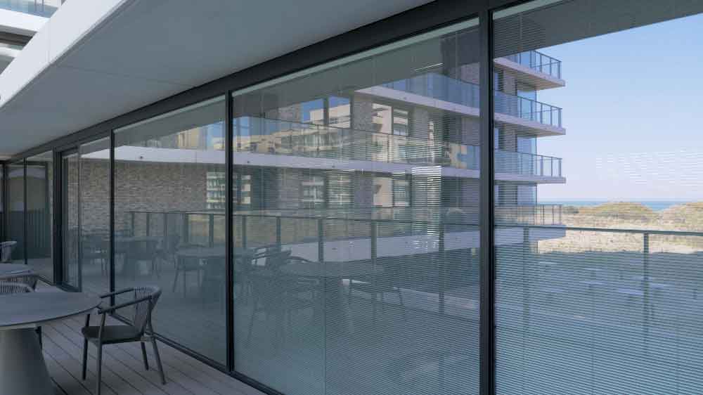 balkonterras modern residentieel gebouw aan de kust met grote aluminium ramen met grote glaspartijen