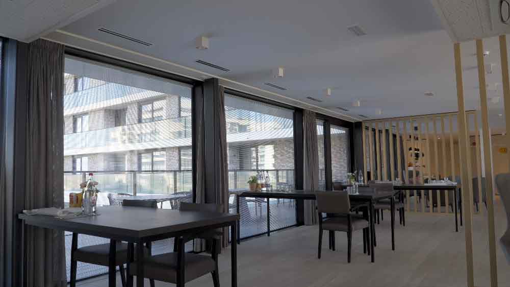 eetruimte modern residentieel gebouw aan de kust met grote aluminium ramen met grote glaspartijen