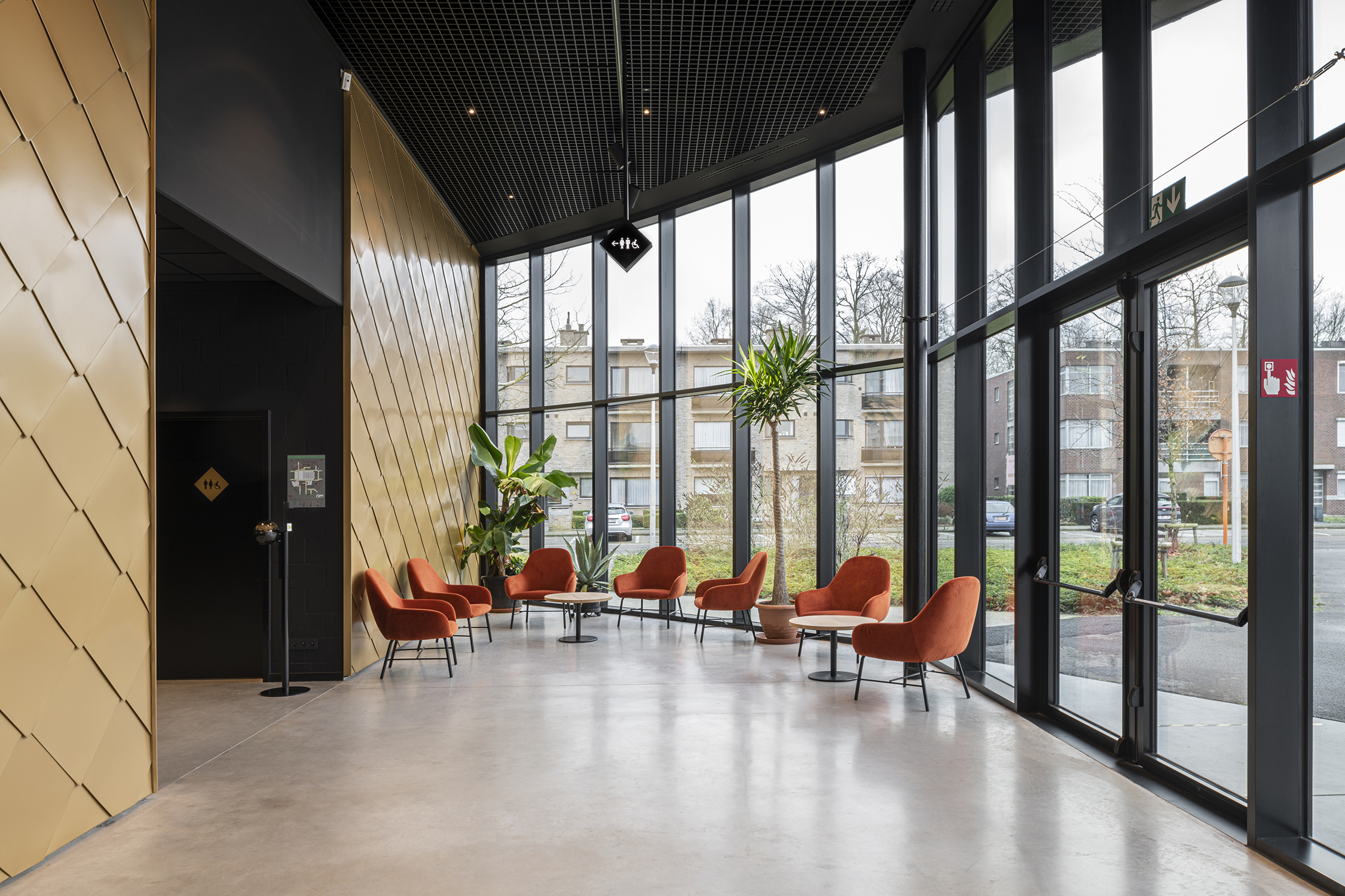 lux zaal met grote ramen met zwarte aluminium profielen die het polyvalente karakter van het gebouw versterken